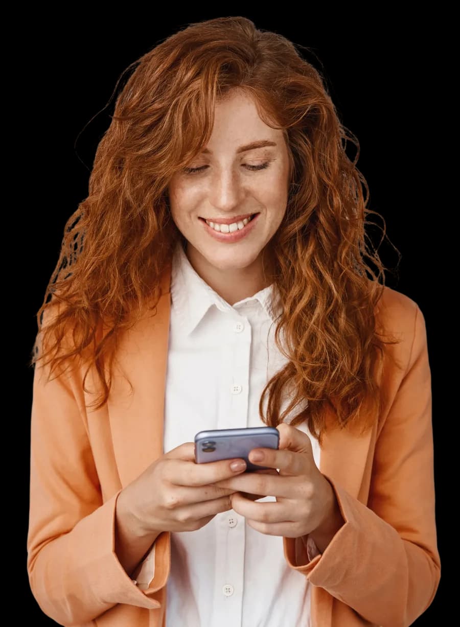 Mulher sorrindo enquanto lê uma mensagem no celular